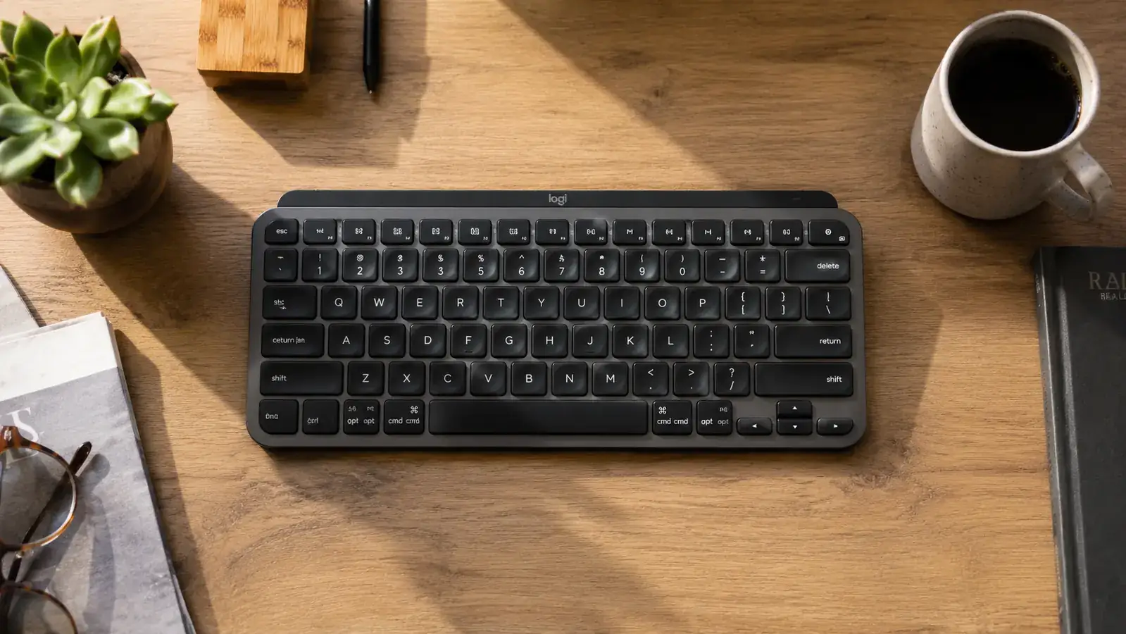 Compact wireless keyboard centered on a clean home office desk with a monitor and minimal accessories