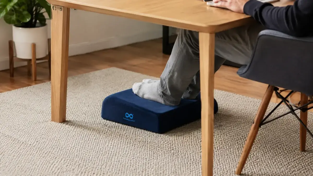 Close-up of the Everlasting Comfort memory foam footrest under a desk with feet resting on the velvet surface