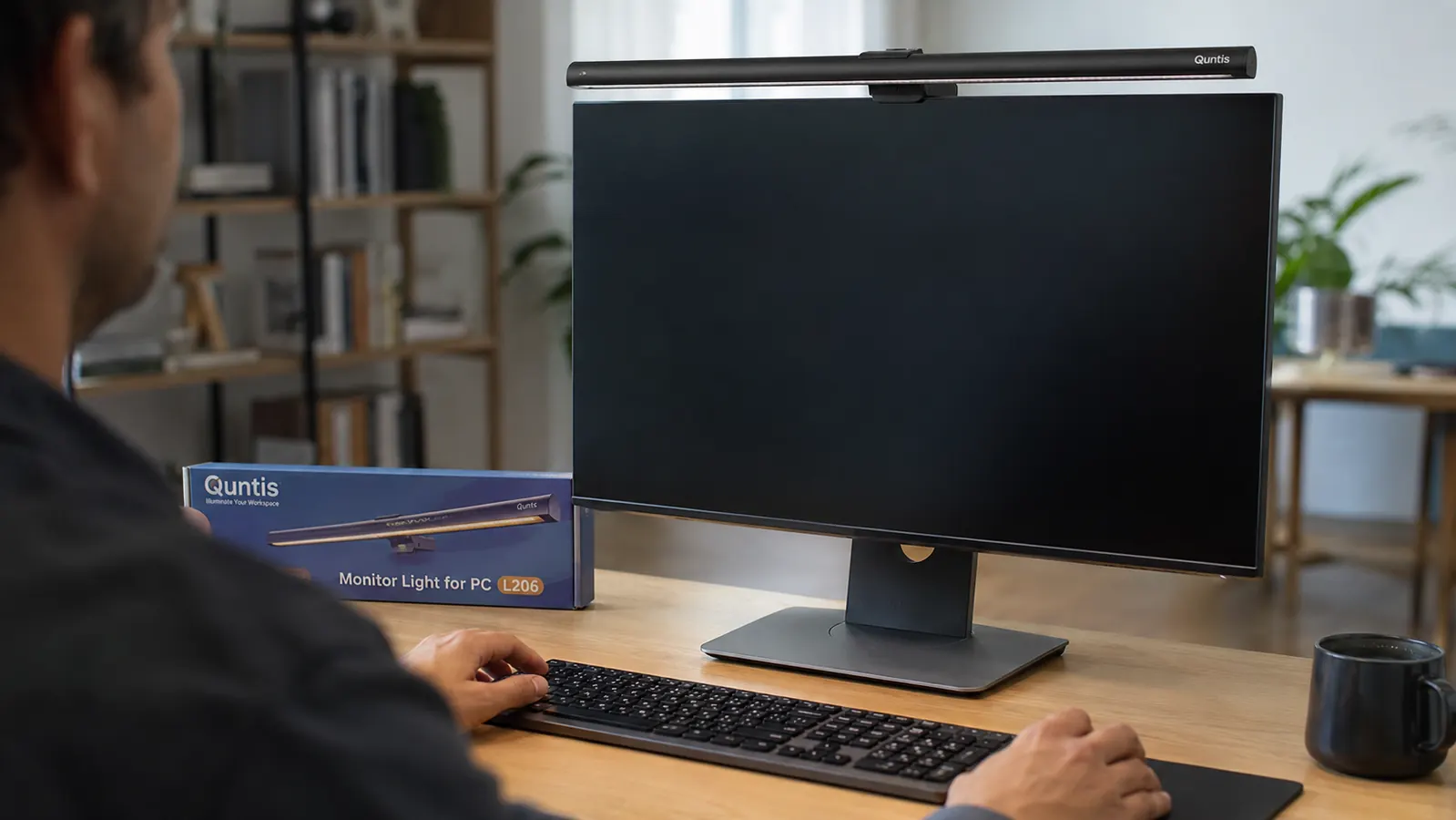 Quntis monitor light bar clipped to the top edge of a computer monitor, USB cable running neatly to the back