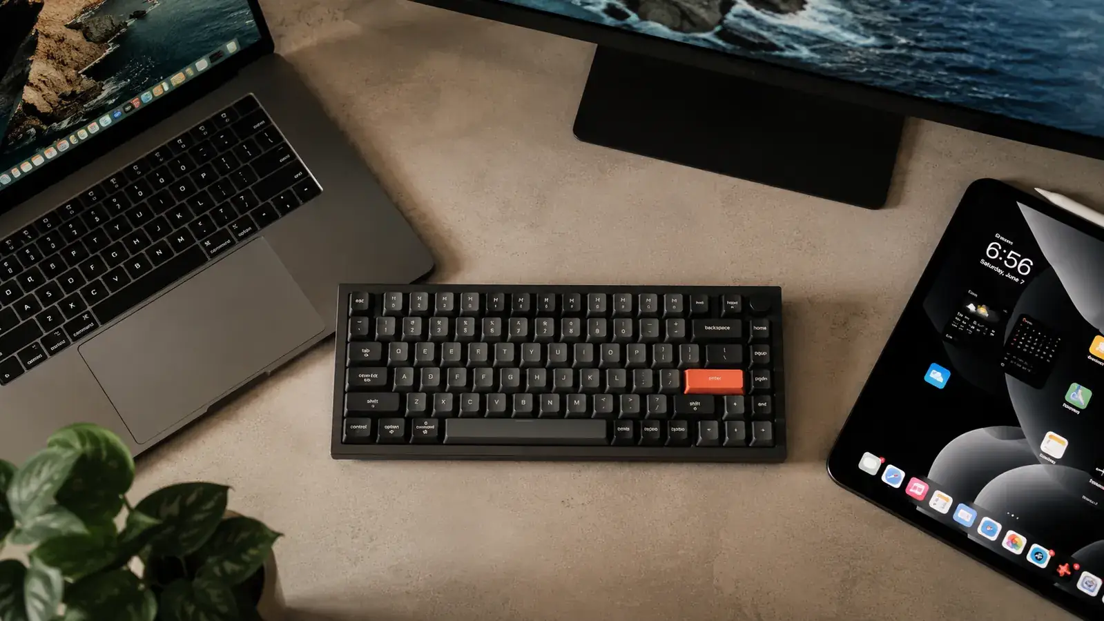 Logitech MX Keys Mini paired to three devices shown on a desk: a laptop, a tablet, and a desktop monitor